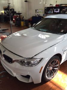 white bmw with hood propped open